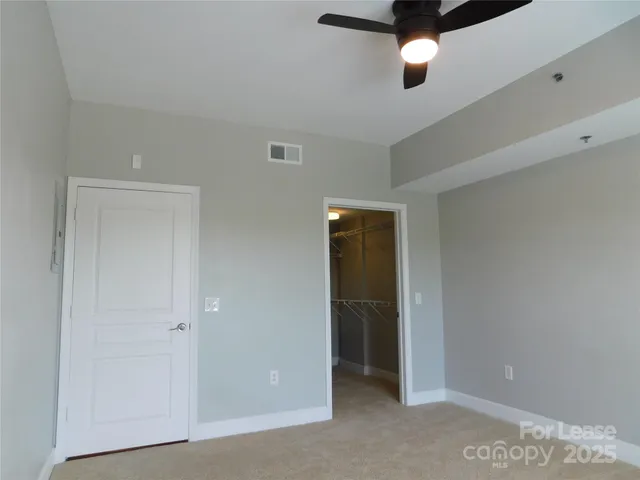 an empty room with window and closet area