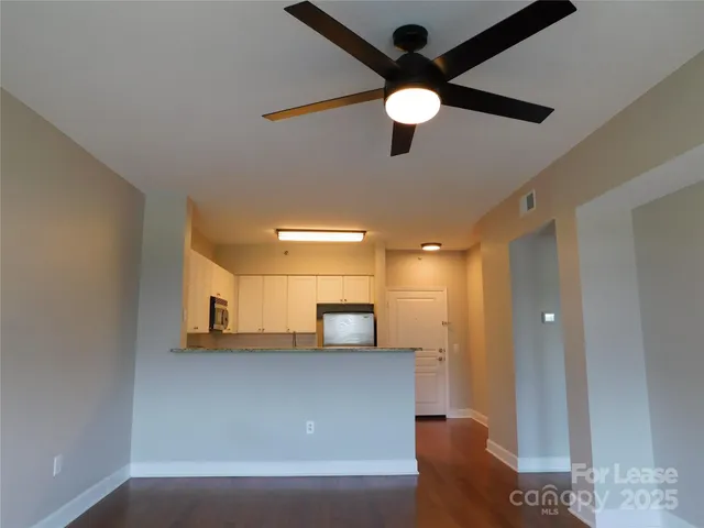 a view of an empty room and kitchen view