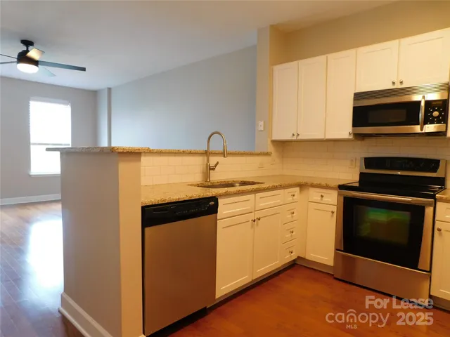 a kitchen with stainless steel appliances granite countertop a stove a microwave and a refrigerator