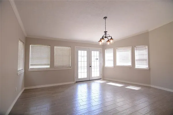 a view of an empty room with a window and wooden floor