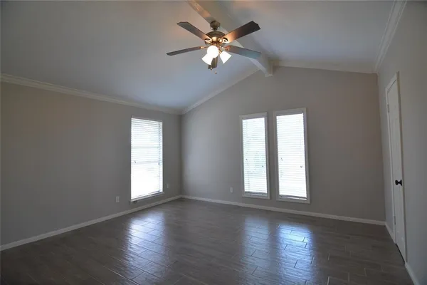 an empty room with wooden floor chandelier fan and windows