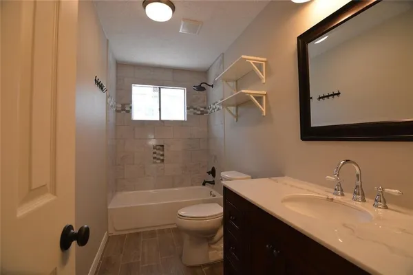 a bathroom with a granite countertop sink toilet and shower