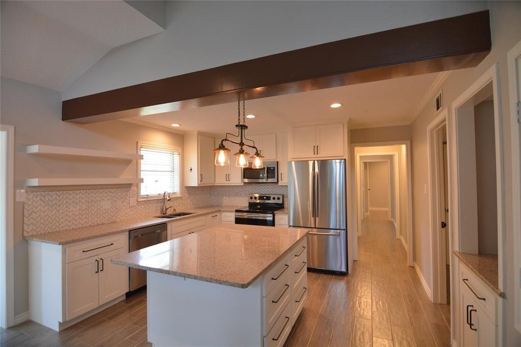 19118 Challe Circle West Spring, TX 77373 - Photo 4 of 21 a kitchen with kitchen island a counter top space a sink stainless steel appliances and cabinets