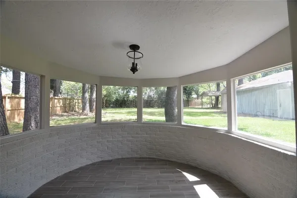 a view of an empty room with a window and a kitchen