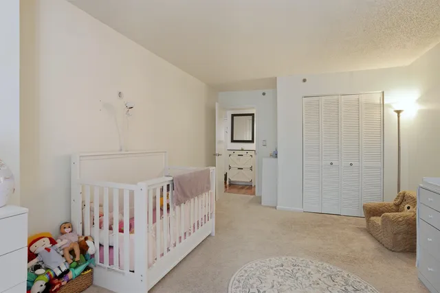 a bedroom with furniture and baby crib