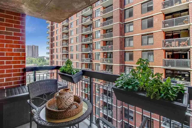 a patio with table and chairs and potted plants