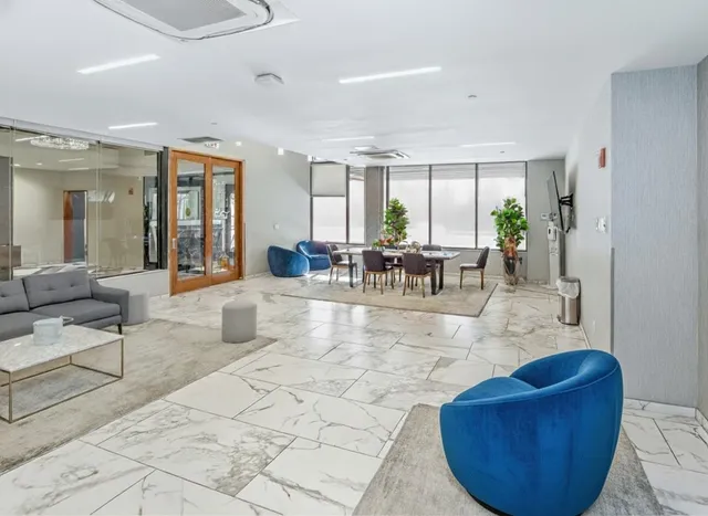 a dining hall with couches a coffee table and chairs