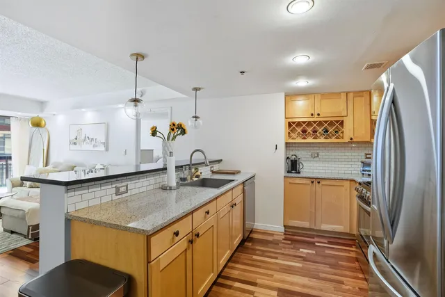 a kitchen with a sink a counter top space stainless steel appliances and cabinets