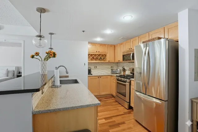 a kitchen with stainless steel appliances granite countertop a sink stove and refrigerator