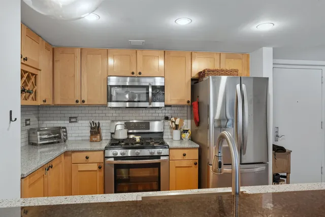 a kitchen with stainless steel appliances granite countertop a refrigerator stove and sink