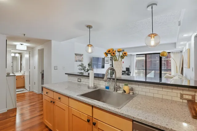 a view of a kitchen with a sink and wooden floor
