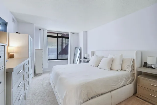 a large bed sitting in a kitchen next to a window