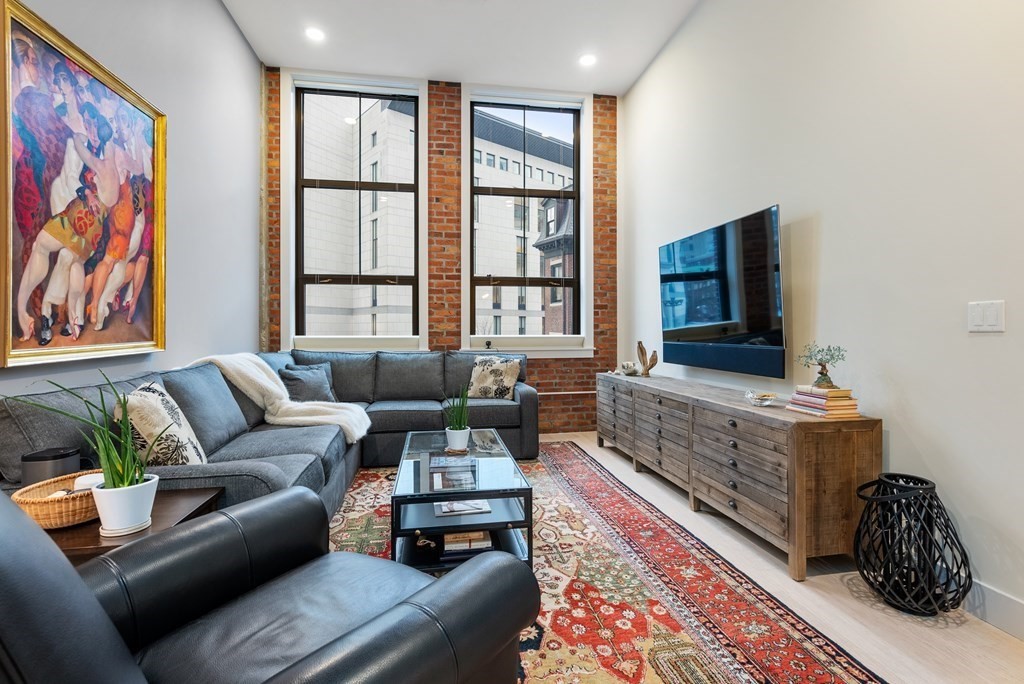 121 Portland Street, Unit 206 Boston, MA 02114 - Photo 1 of 35 a living room with furniture and a rug