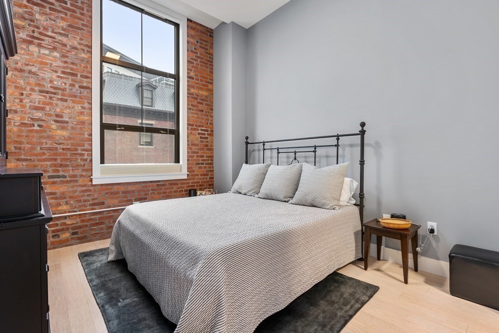 121 Portland Street, Unit 206 Boston, MA 02114 - Photo 15 of 35 a large bed sitting in a bedroom next to a window