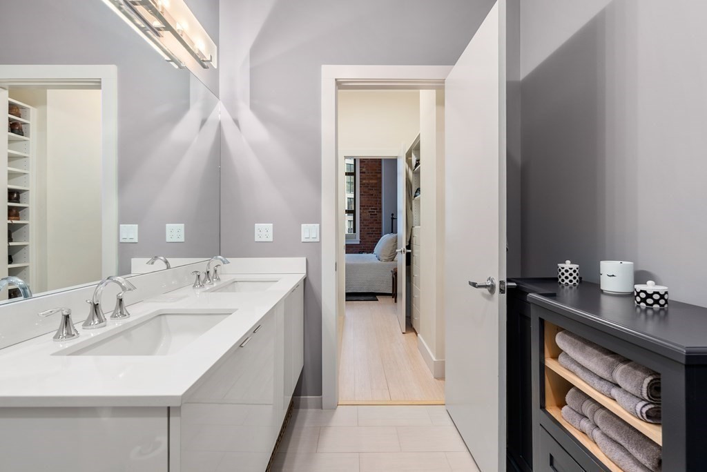 121 Portland Street, Unit 206 Boston, MA 02114 - Photo 19 of 35 a en suite bathroom with a double vanity sink and a mirror
