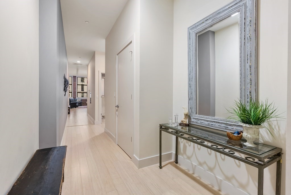 121 Portland Street, Unit 206 Boston, MA 02114 - Photo 21 of 35 a view of a hallway with wooden floor and a potted plant