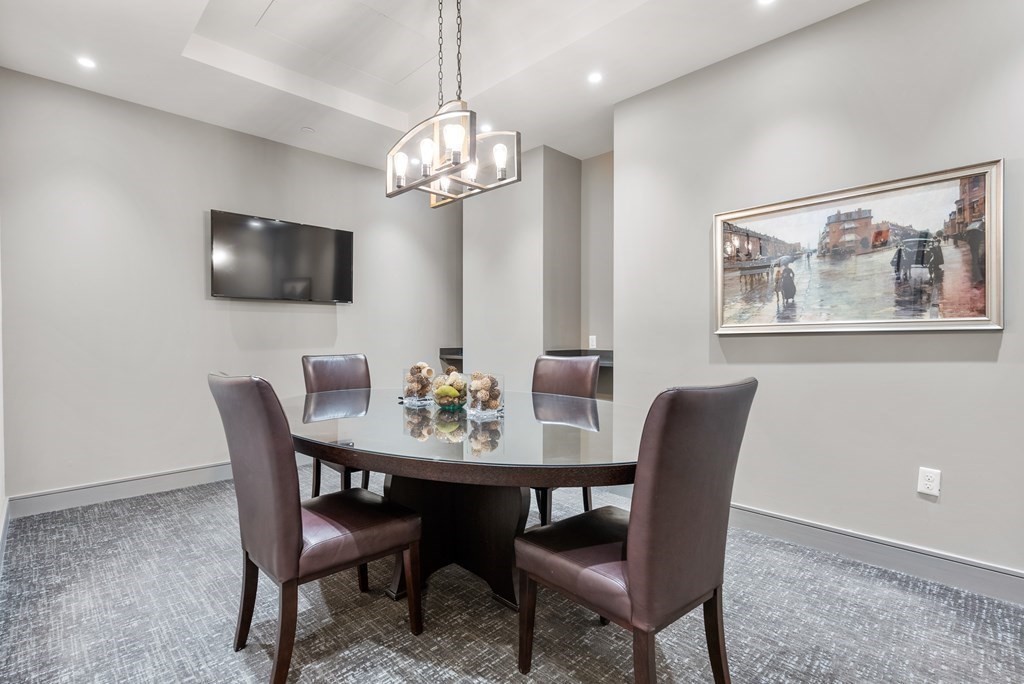 121 Portland Street, Unit 206 Boston, MA 02114 - Photo 26 of 35 a view of a dining room with furniture a chandelier and wooden floor