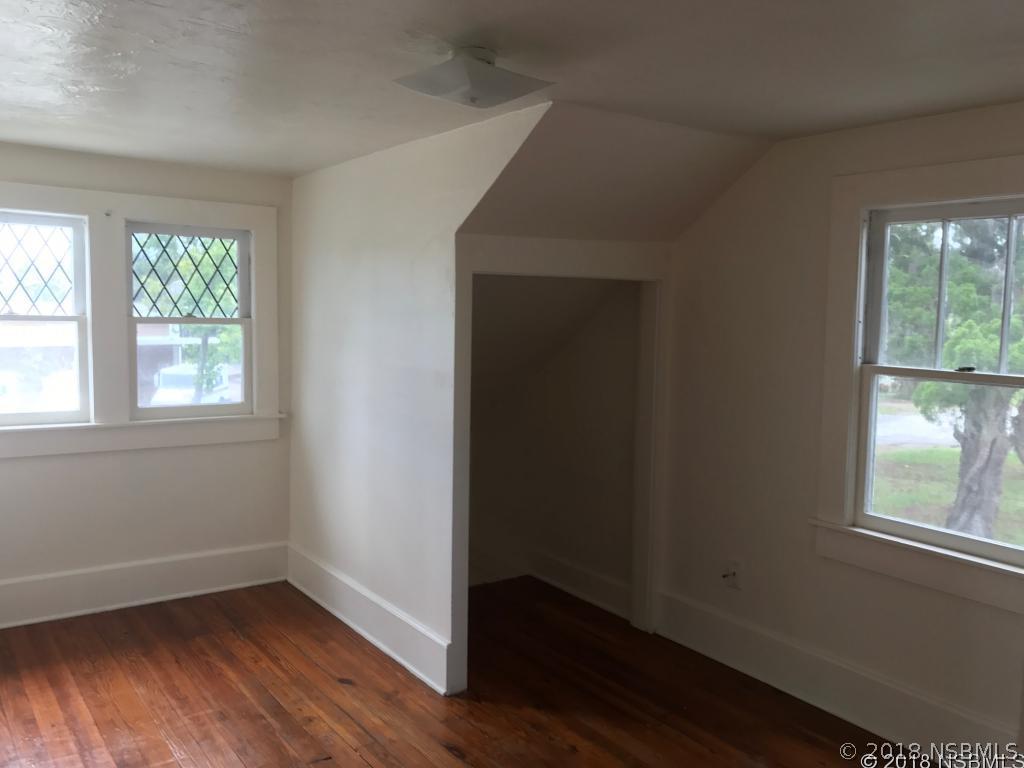 111 Snyder Street Edgewater, FL 32132 - Photo 12 of 16 an empty room with wooden floor and windows