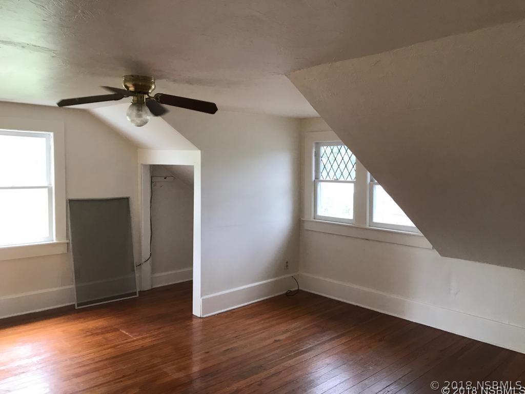 111 Snyder Street Edgewater, FL 32132 - Photo 15 of 16 a view of an empty room with wooden floor and a window