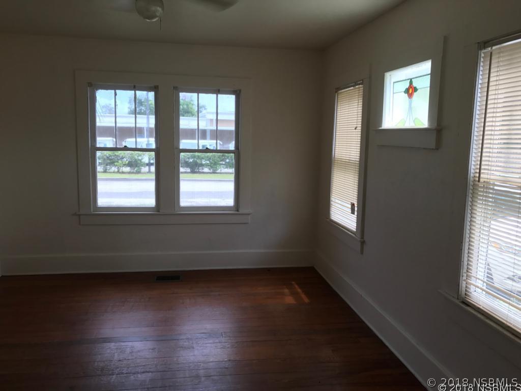 111 Snyder Street Edgewater, FL 32132 - Photo 4 of 16 an empty room with wooden floor and windows