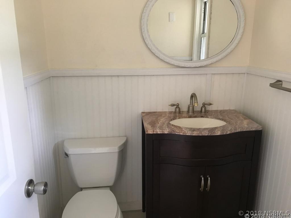 111 Snyder Street Edgewater, FL 32132 - Photo 8 of 16 a bathroom with a toilet a sink and a mirror