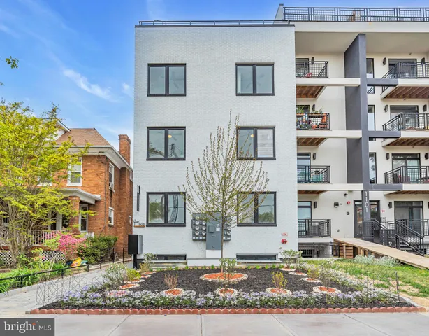 a front view of a residential apartment building with a yard