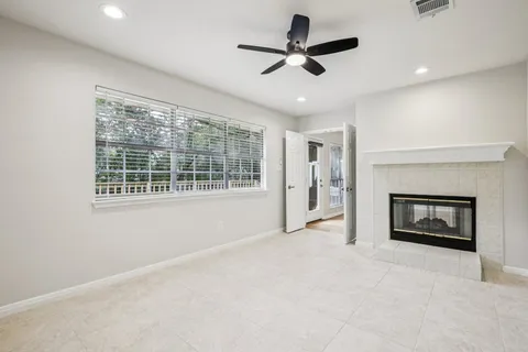 a view of an empty room with a fireplace and a window