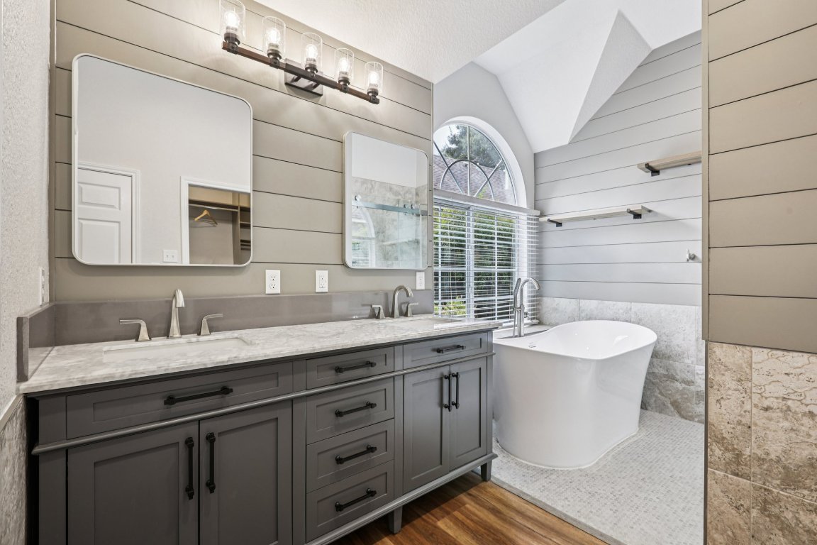 8109 Isaac Pryor Drive Austin, TX 78749 - Photo 15 of 20 a spacious bathroom with a double vanity sink a mirror and a bathtub