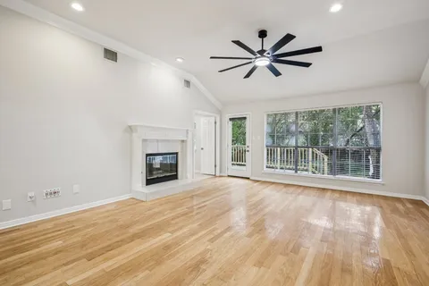 a view of empty room with wooden floor and fireplace