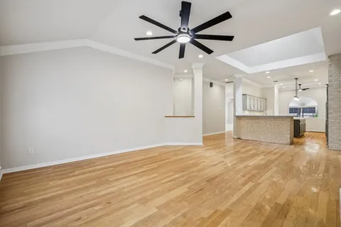 an empty space with wooden floor and windows