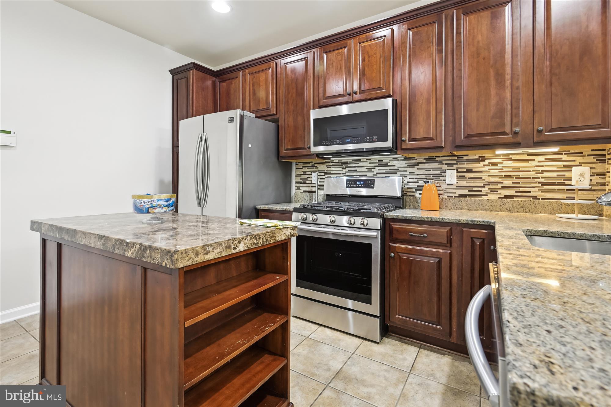 22678 Verde Gate Terrace Brambleton, VA 20148 - Photo 7 of 39 a kitchen with granite countertop wooden cabinets and stainless steel appliances