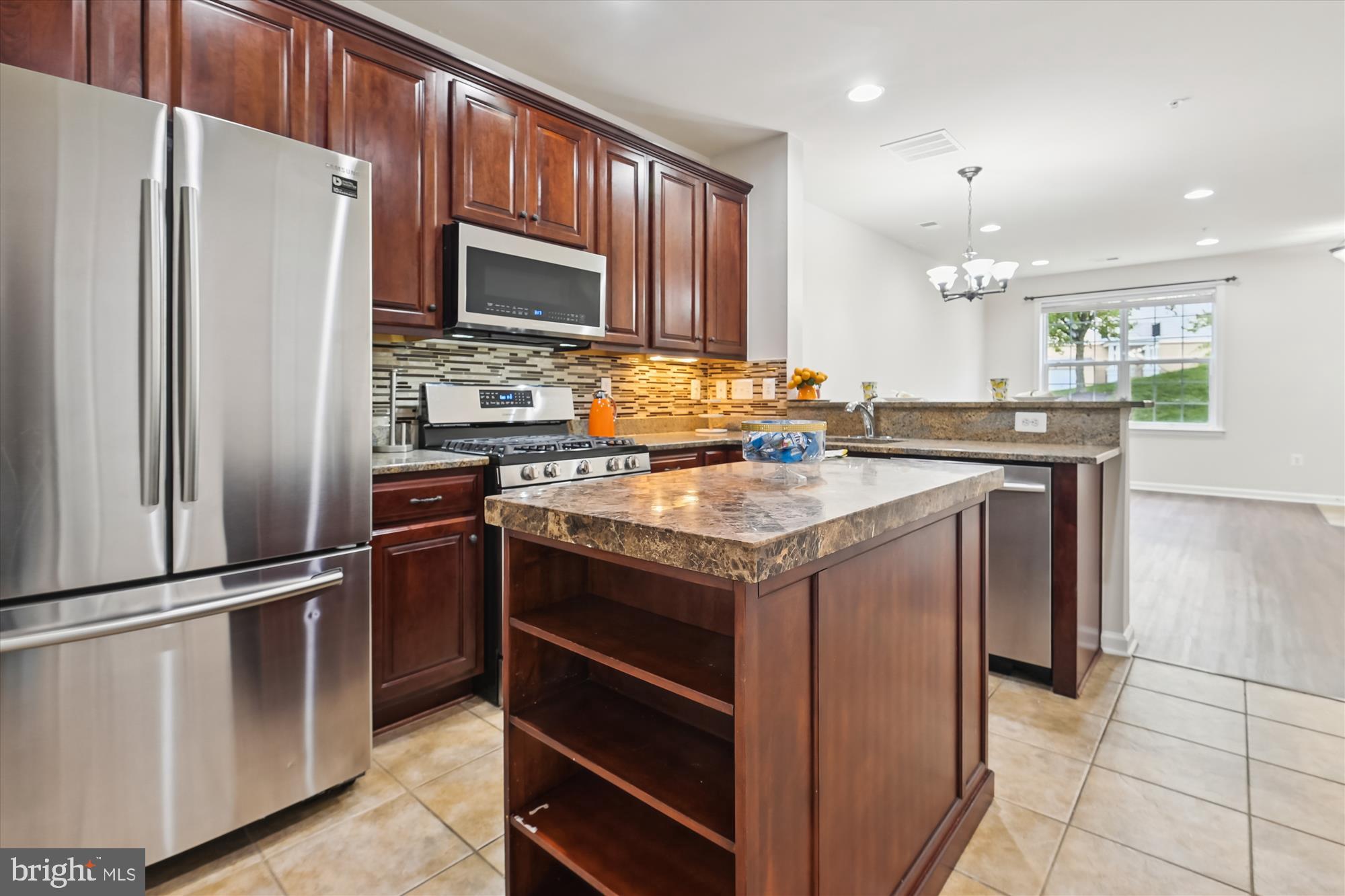 22678 Verde Gate Terrace Brambleton, VA 20148 - Photo 8 of 39 a kitchen with kitchen island granite countertop stainless steel appliances and counter space