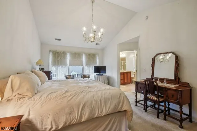 a spacious bedroom with a bed and a chandelier