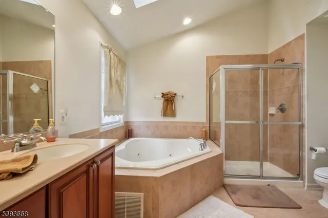 a bathroom with a granite countertop bathtub sink vanity and mirror