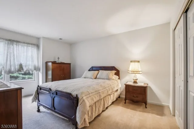 a bedroom with a bed and large windows