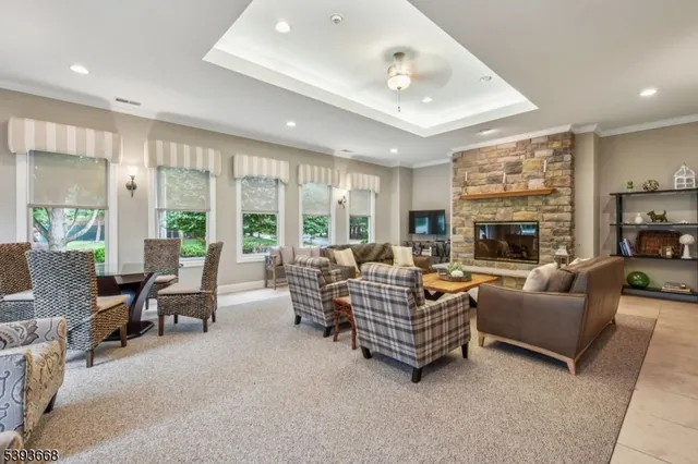 a living room with furniture ceiling fan and large windows
