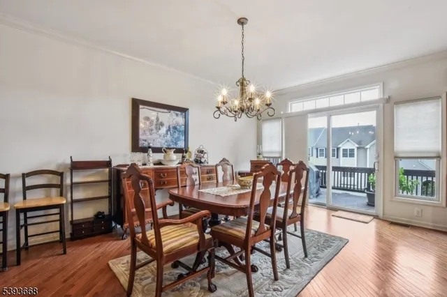 a view of a dining room with furniture a chandelier and wooden floor