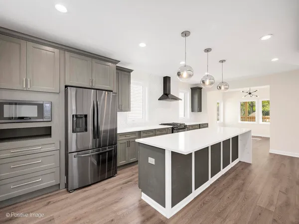 an open kitchen with a sink and wooden floor