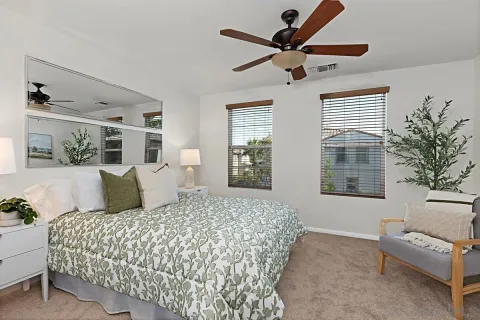 a bedroom with a large bed chandelier and a window
