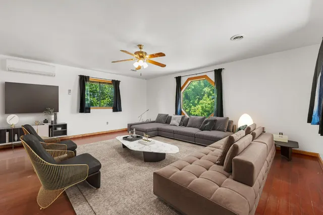 a living room with furniture kitchen view and a large window