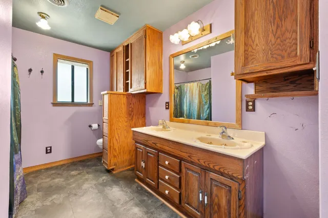 a spacious bathroom with a granite countertop sink and a mirror