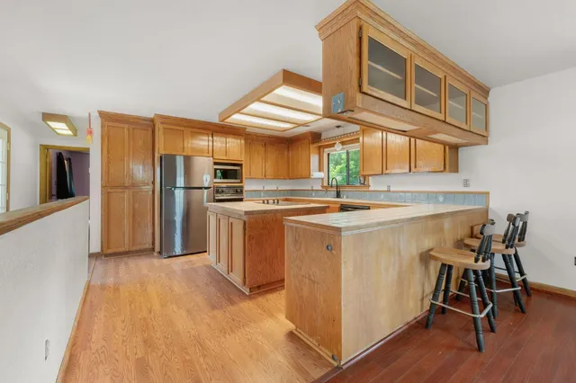 a kitchen with refrigerator cabinets and wooden floor