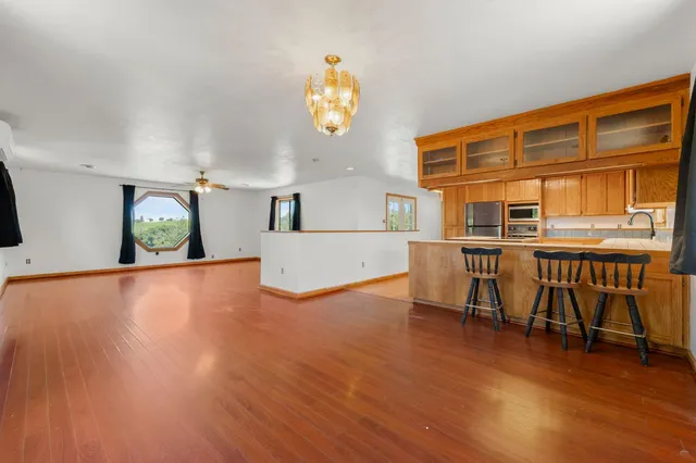 a view of a dining room with furniture a chandelier and wooden floor