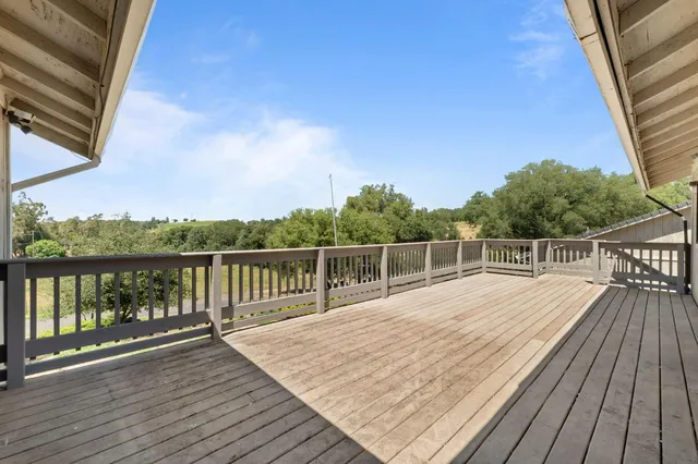a view of balcony with wooden floor and fence