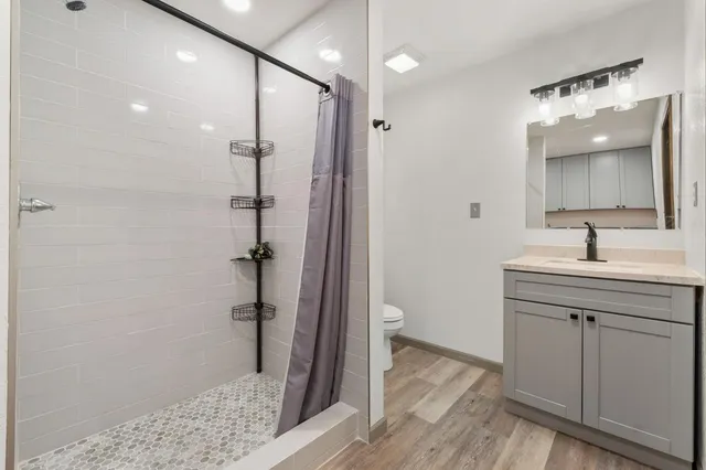 a bathroom with a shower sink and toilet