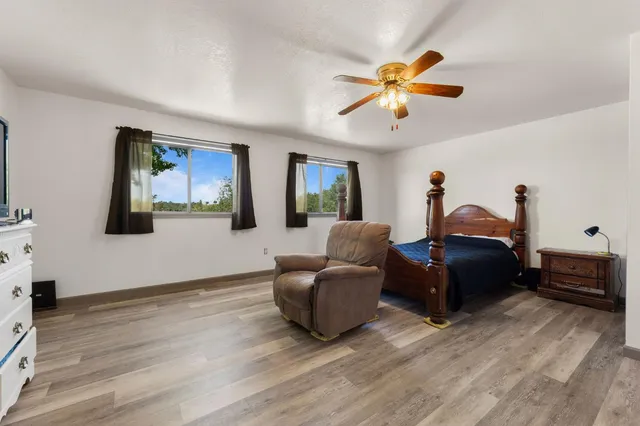 a living room with furniture a ceiling fan and a wooden floor