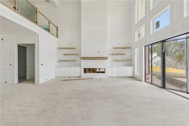 a view of an empty room with a fireplace and a window