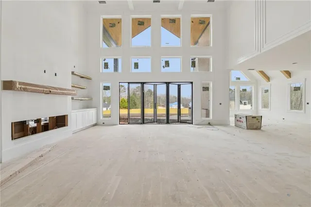 a view of an empty room with a fireplace and a window