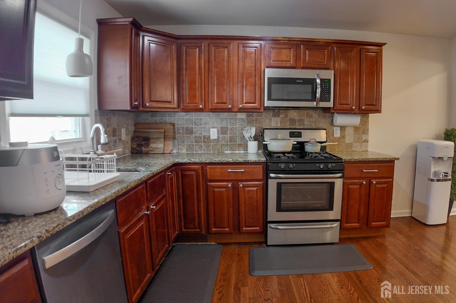 202 Jackson Avenue Edison, NJ 08837 - Photo 12 of 35 a kitchen with granite countertop a stove top oven microwave and cabinets