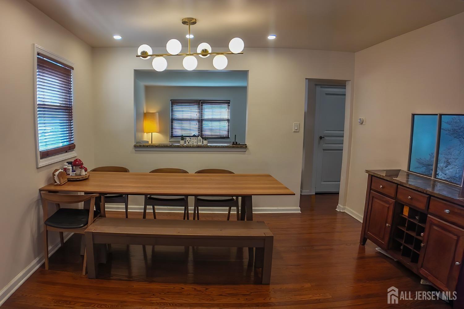 202 Jackson Avenue Edison, NJ 08837 - Photo 9 of 35 a dining room with wooden floor a chandelier a wooden table and chairs